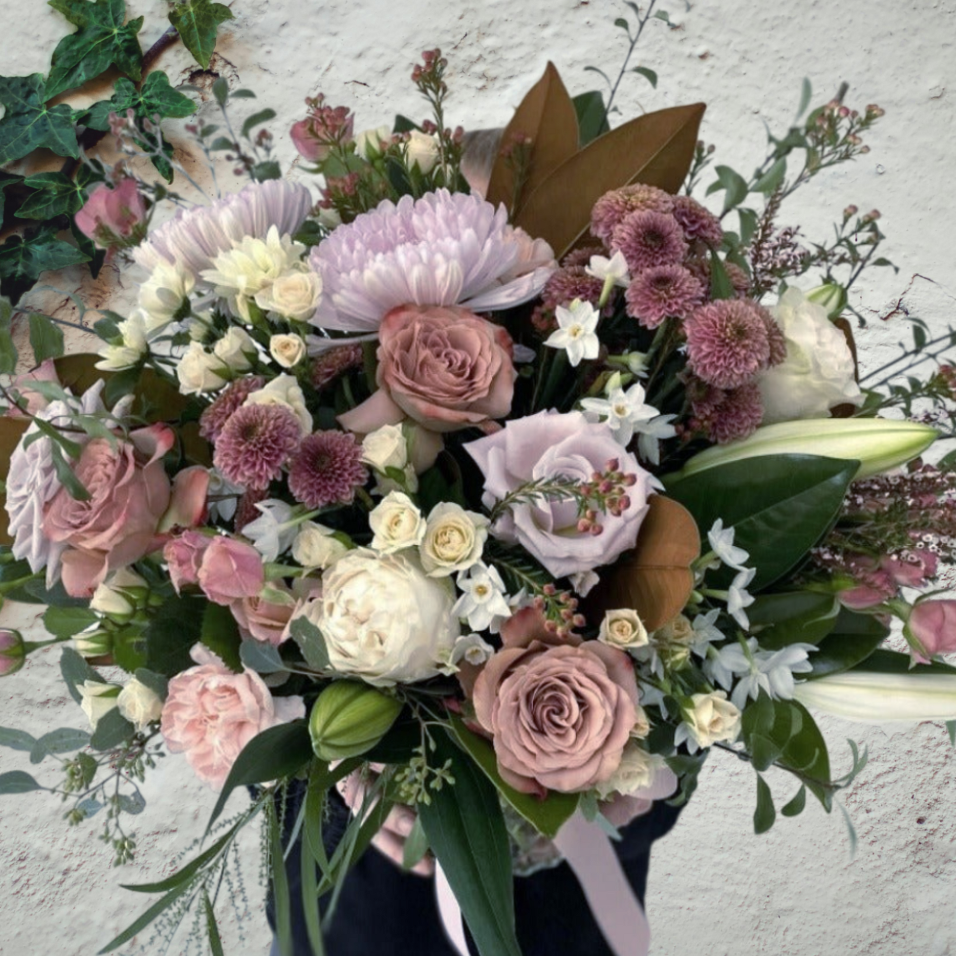 Seasonal soft coloured flowers presented in a vase